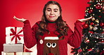 Christmas, confused and girl in studio for thinking, tradition and shrug on red background. Xmas, holiday season and child with presents, unsure and decision with idea, choice and decide for gifts