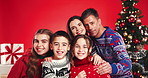 Christmas, face and happy family with children for holiday, care and love on red studio background. Xmas, mother and father with kids, siblings laugh and parents with portrait for festive celebration