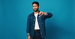 Face, fashion and thumbs down with man on blue background for negative opinion or rejection. Disagreement, feedback and frown with unhappy person isolated on studio space for clothing or style advice