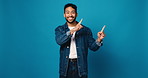 Face, smile and pointing up with man in studio for sign up, announcement and sale news. Portrait, male person and hand gesture for coming soon, show information and giveaway steps on blue background