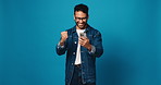 Happy man, winning or phone with good news in studio for bonus or success on a blue background. Excited, male person or model with fist pump on mobile smartphone for profit investment on mockup space