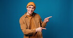 Studio, face and man with presentation, pointing and smile for discount offer, mockup space and ads. Blue background, happy and person with gesture for announcement, suggestion or excited with news
