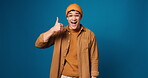 Face, smile and man with thumbs up, congratulations and wow on blue background in studio. Portrait, happy Gen z person and OMG for approval with support, achievement and opinion or vote on space