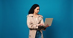 Woman, journalist and laptop for typing in studio for review, research or story on blue background. Person, writer and computer for editing process, article or draft development for online newsletter