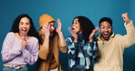 Excited people, friends and celebration with applause in studio for victory on a blue background. Group, community or happy fans with smile, clapping or fist pump for team success or winning together