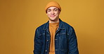 Style, beanie and face of man in studio with casual, cool and trendy outfit with confidence. Happy, winter and portrait of male student from New York with fashion clothes by yellow background.