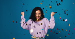 Happy woman, winning and celebration with confetti in studio for bonus prize on a blue background. Portrait, female person or excited model with fist pump or applause for success, party or jackpot