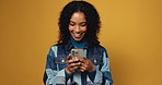 Girl, phone and chat with laugh in studio, notification and funny video on yellow background. Woman, smartphone and scroll on mobile app with mockup space, meme and happy with post on social network