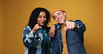 Couple, students and face with point at you in studio, happy and recruitment for university on background. Gen z man, woman and smile with choice, portrait and call to action for college education