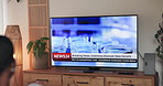 Person, home and watching tv screen for breaking news with back for virus, pandemic and headlines in lounge. Television, broadcast and monitor for program, report or info on show for medical research