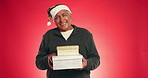 Christmas, box and shake with face of old man in studio for announcement, holiday season and laugh. Festive celebration, Xmas present and December gift with elderly person on red background space