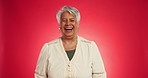 Senior, happy woman and face with laugh in studio for funny joke or humor on a red background. Portrait, elderly or female person with smile for comedy, festive spirit or positive attitude on space