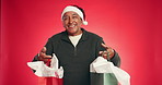 Christmas, face and old man in studio, gift and decision with holiday season on red background. Xmas, pensioner and mature person with tradition, presents and options with smile, festive and package