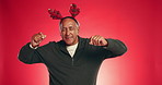 Christmas, dance and senior man in studio with decoration for holiday or festive season. Happy, mockup space and mature person with energy, antlers and fun for xmas celebration on red background