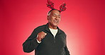 Christmas, dance and face of senior man in studio with decoration for holiday or festive season. Happy, mockup space and portrait of mature person with energy for xmas celebration on red background