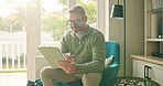 Mature, happy man or research with tablet in home for day trading, investment or online app. Male person, investor or trader browsing with technology for virtual finance, platform or network in house