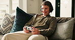 Boy, child and headphones on sofa with video game controller, strategy and smile with online contest at home. Kid, gamer and happy with click, challenge and audio for esports on couch in living room