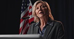American flag, government and speech with woman candidate at podium for political campaign. Democracy, election and politics with mature speaker in auditorium for democratic or United States vote