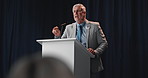Speech, mature man and politician on podium for election, democracy or political campaign. Talking, microphone and male speaker at conference, meeting or seminar for vote for activism at convention.