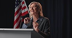 American flag, democracy and speech with woman candidate at podium for political campaign. Election, government and politics with mature speaker in auditorium for democratic or United States vote