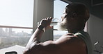 Mature, black man and thinking with water in gym for hydration or natural sustainability. Fitness, male person or window with mineral liquid or thirst for recovery, endurance or break in health club