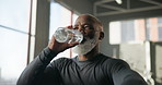 Mature, black man and fitness with water bottle in gym for hydration or natural sustainability. Active, male person or break with mineral liquid or drink for endurance, rest or thirst in health club