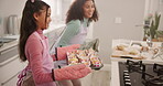 Woman, daughter and remove cupcake from oven for baking, help for support and bonding in home. Mom, girl kid and growth for bakery skills with family in kitchen for cake, baked goods and happiness