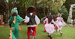 Children, outdoor and running at halloween, play and excited for trick or treat event for sweets in garden. Kids, boys and lantern basket on lawn for costume party, candy and back with race for fun