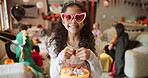Candy, face and halloween with happy girl in living room of home for celebration, holiday or tradition. Bucket, princess and smile of child in apartment with sweet treats for trick or treating