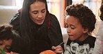 Halloween, children and drawing on pumpkin with mother or parent for learning in home. Kids, holiday and celebration with vegetable for decoration, writing or creative art with foster family at party