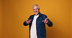 Face, dancing and senior man in studio, smile and happiness on yellow background. Portrait, space and mature person with movement, celebration and energy with wellness, cheerful and retirement