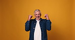 Face, mature man and celebration in studio for lottery winner, game show bonus or cheering. Mockup space, excited person and victory fist on yellow background for milestone, giveaway prize or success