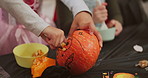Halloween, hands and pumpkin carving with children in home together for activity or tradition. Creative, holiday and vegetable with group of kids in living room of apartment for spooky decoration