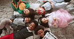 Face, friends and children with smile, halloween or happy for spooky season, floor or group in home. Above, excited and creative costumes for party, fantasy and holiday celebration for kids in house