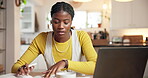 Budget, laptop and writing with black woman in kitchen of home for accounting or remote work. Computer, earphones and notebook with freelance employee in apartment for banking, finance or investment