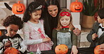 Halloween, children and drawing on pumpkin with mother, parent and smile for learning in home. Hug, holiday and celebration with vegetable for decoration, writing or creative art with family at party