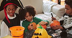 Children, happy and pumpkin decoration for halloween, lantern and art for party in living room. Kids, group and boy with costume, drawing and vegetables with smile, excited and creativity at home