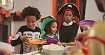 Halloween, party and children in costume with candy for celebration, festive event and holiday. October, spooky season and kids with outfit in home with sweets, snacks and chocolate for tradition