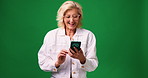 Mature woman, laughing and social media with phone in studio for funny joke on a green background. Female person, smile or model with mobile smartphone for online humor or comedy on mockup space