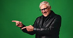 Face, pointing and smile of mature man on green screen for marketing, offer or promotion. Advertising, hand gesture and presentation with happy person on studio space for announcement or information
