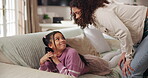 Chatting, phone or social media with mother and daughter on sofa in home for safety or security. App, gossip or secret with girl child and single parent in apartment living room for responsibility
