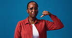 Face, thumbs up and black woman in studio, down and decision on blue background. Portrait, mockup space and African person with hand gesture, options and choice with confused opinion and vote emoji