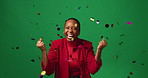 Happy, black woman and winning with confetti in studio for celebration on a green background. Portrait, excited or female person with smile, glitter or applause for party prize, promotion or success