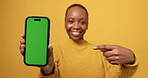 Hands, phone and point in studio with green screen, choice and mockup space on yellow background. Person, smartphone and chromakey ux with promotion, mobile app or review for digital marketing launch