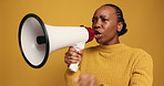 Megaphone, screaming and  black woman in studio for protest, democracy or human rights activism. Shouting, bullhorn and African female person with voice for politics with rally by yellow background.