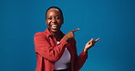 Happy, black woman and pointing with advertising in studio for marketing on a blue background. Portrait, female person or model with smile or showing list for selection or options on mockup space