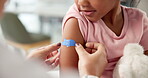 Hands, doctor and plaster on child at hospital for first aid, injection and virus vaccination. Pediatrician, helping and kid with bandage for medical checkup, immunization shot and wound protection