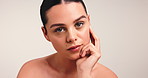 Hands, skincare and face of woman in studio for beauty, self care and clear skin aesthetic. Dermatology glow, shine and collagen with female person and touch on white background for mockup space