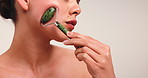 Jade roller, skincare and woman in studio for facial routine, anti aging massage and smooth skin. Beauty, space and person with tools for dermatology benefits, wellness and detox on white background