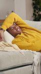 Illness, woman and stomach pain on sofa in home for menstruation, agony or uncomfortable ache. Discomfort, black person or belly cramps with endometriosis, constipation or pelvic inflammatory disease
